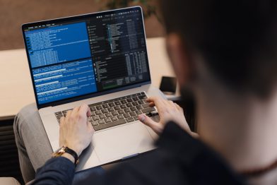 Benchmark as a Service Close-up man schrijft code op een laptop.