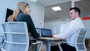 Koenen en Co twee collega's aan bureau voor laptop